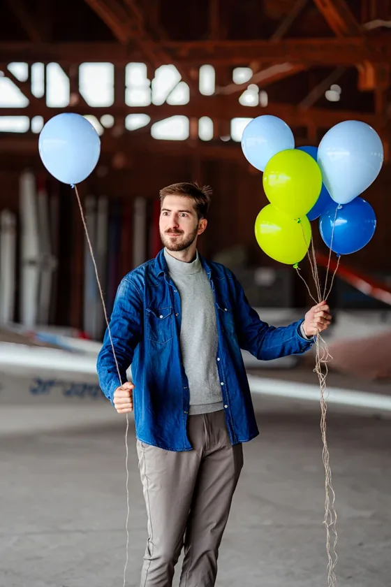 Sesja zdjęciowa High-Flyer — mężczyzna z balonami w hangarze