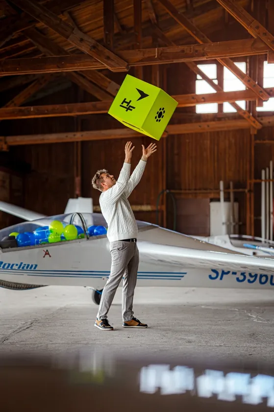 Sesja zdjęciowa High-Flyer — mężczyzna podrzucający limonkowe pudełko z logo HF